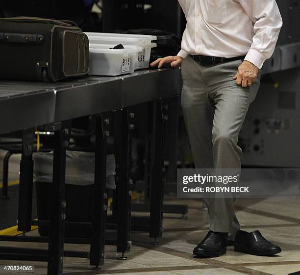 An air traveler puts his shoes back on after passing through the Transportation Security Administration security check at Los Angeles International...