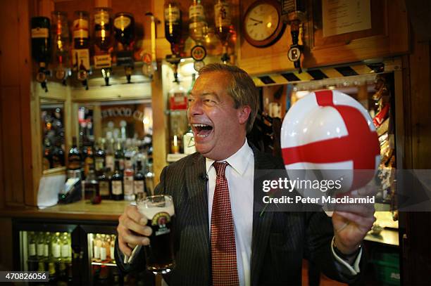 Independence Party leader Nigel Farage celebrates St George's Day with a pint in the Northwood Club after meeting veterans on April 23, 2015 in...
