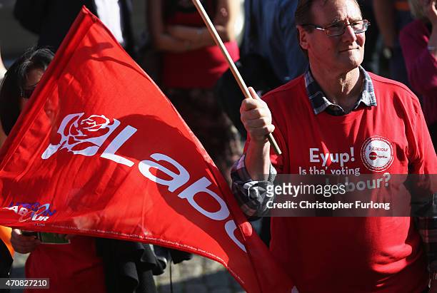 Labour supporters wave flags ahead of Labour Party leader Ed Miliband's speach at an NHS rally at Leeds Town Hall on April 23, 2015 in Leeds,...
