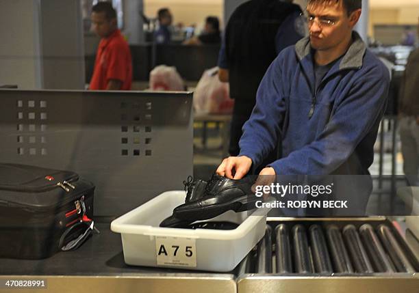 An air traveler places his shoes in a bin before passing through the Transportation Security Administration security check at Los Angeles...