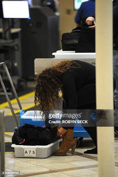 An air traveler puts her shoes back on after passing through the Transportation Security Administration security check at Los Angeles International...