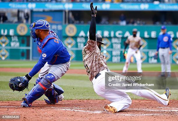 Josh Harrison of the Pittsburgh Pirates slides into home plate past Wellington Castillo of the Chicago Cubs after scoring the go-ahead run in the...