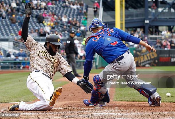 Josh Harrison of the Pittsburgh Pirates slides into home plate past Wellington Castillo of the Chicago Cubs after scoring the go-ahead run in the...