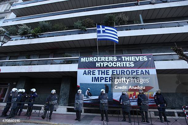 Policemen stand at the entrance of the European Commission offices after protesters hang a huge banner on the European Commission offices in Athens,...