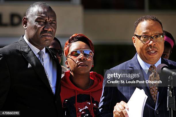 Michael Brown's mother, Lesley McSpadden, center, closes her eyes as attorneys Benjamin Crump, left, and Anthony Gray announce a wrongful-death...