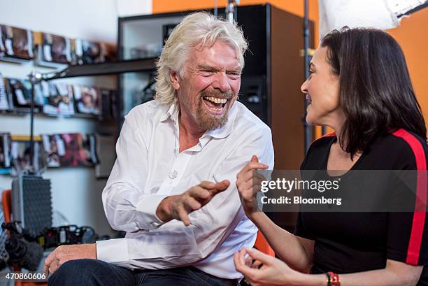 Richard Branson, chairman and founder of Virgin Group Ltd., left, and Sheryl Sandberg, chief operating officer of Facebook Inc., have a laugh during...