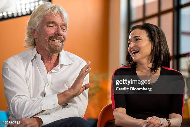 Richard Branson, chairman and founder of Virgin Group Ltd., left, speaks as Sheryl Sandberg, chief operating officer of Facebook Inc., laughs during...