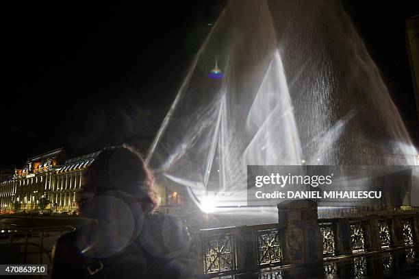 Woman looks at a ghost ship, a tridimensional light projection on water in Bucharest April 23, 2015 during an event celebrating UNESCO 2015-Year of...