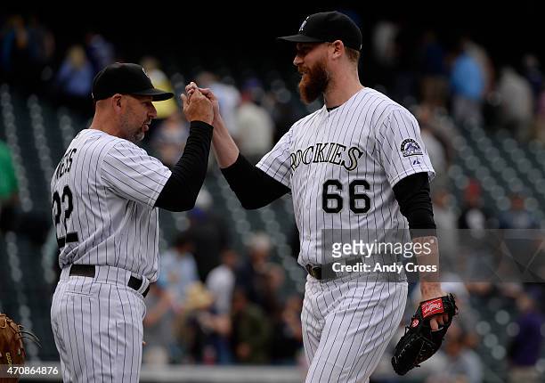Colorado Rockies manager Walt Weiss greets Colorado Rockies relief pitcher John Axford as he comes off the field after holding off the San Diego...