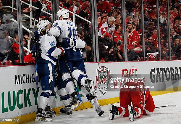 Ondrej Palat of the Tampa Bay Lightning celebrates with Nikita Kucherov next to Darren Helm of the Detroit Red Wings after a overtime game winning...