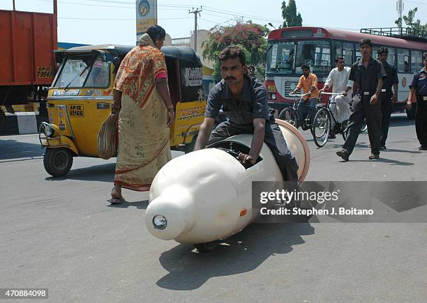 Man rides a condom car outside the Sudha Cars Museum. He is a Guinness World Record holder for making the Largest Tricycle in the World.