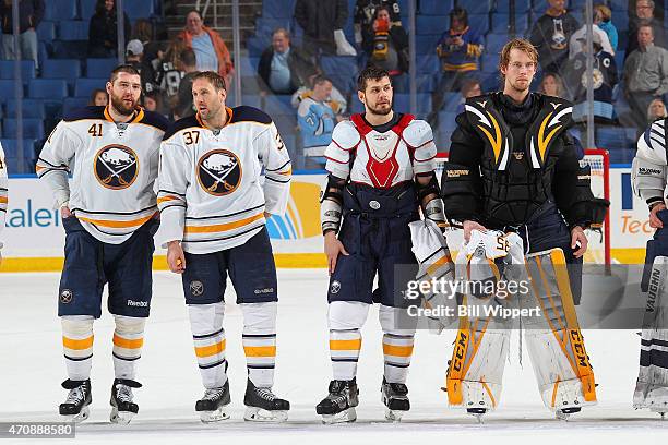 Andrej Meszaros, Matt Ellis, Patrick Kaleta and Anders Lindback of the Buffalo Sabres wait to hand their jerseys to fans after their game against the...