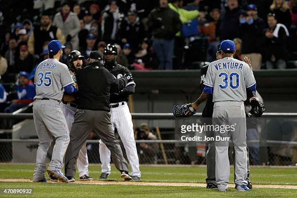 Yordano Ventura of the Kansas City Royals talks to umpire Sam Holbrook while umpire Tim Timmons and first base coach Daryl Boston of the Chicago...