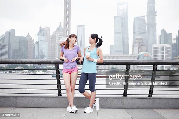 female friends on bridge in shanghai, china - running shorts stockfoto's en -beelden