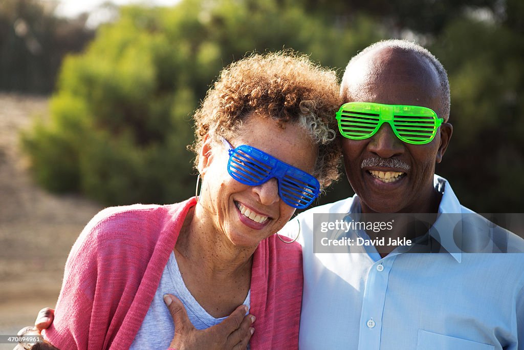 Senior couple wearing blue and green plastic glasses