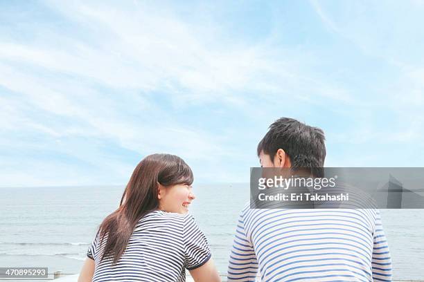 rear view of couple at coast, face to face and laughing - japanese couple stock pictures, royalty-free photos & images