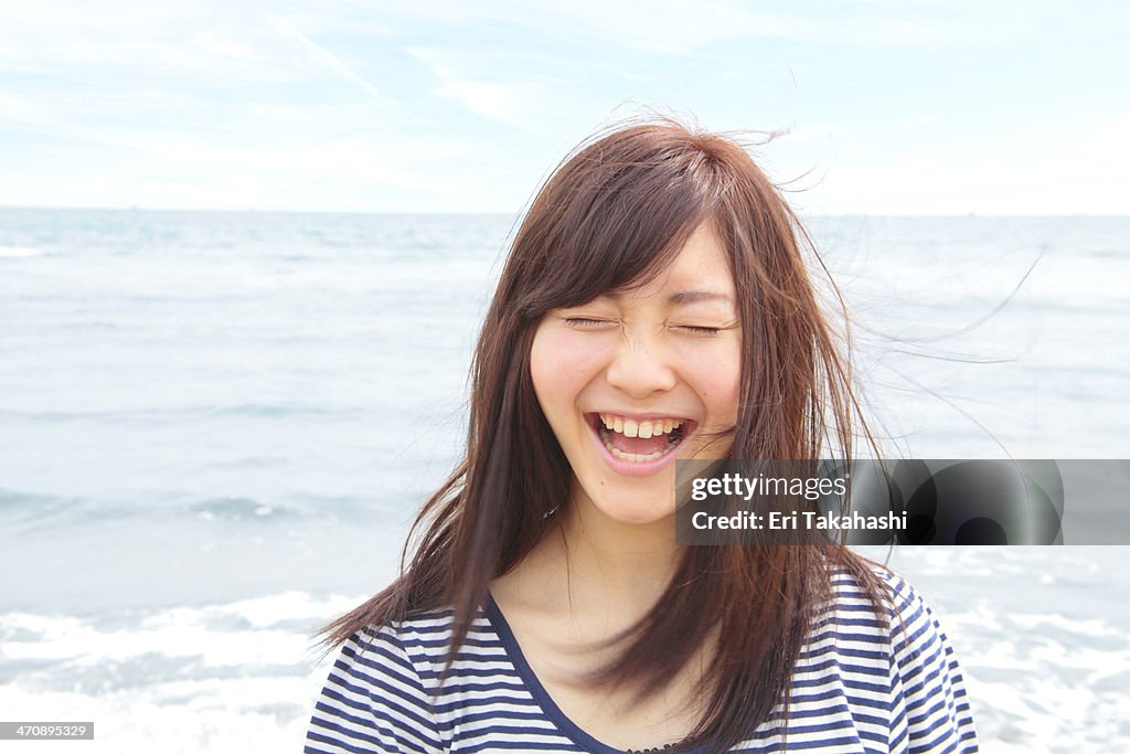 Portrait of young woman with eyes closed, laughing