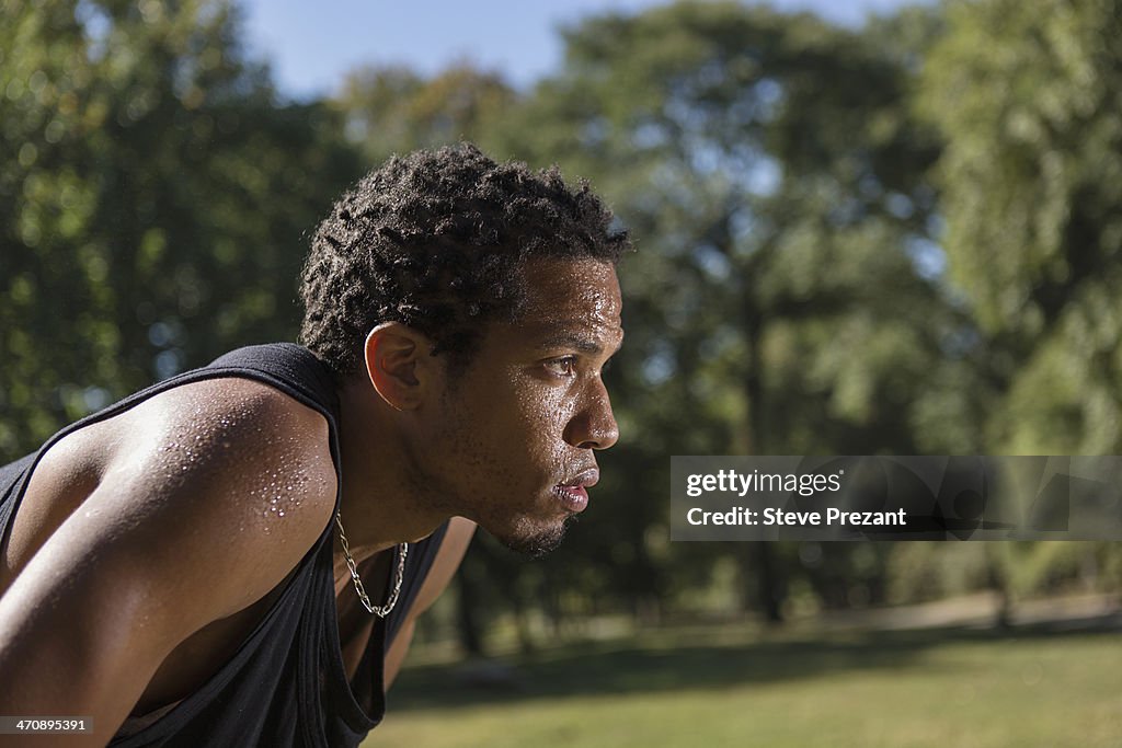 Portrait of young man wearing black vest, side view