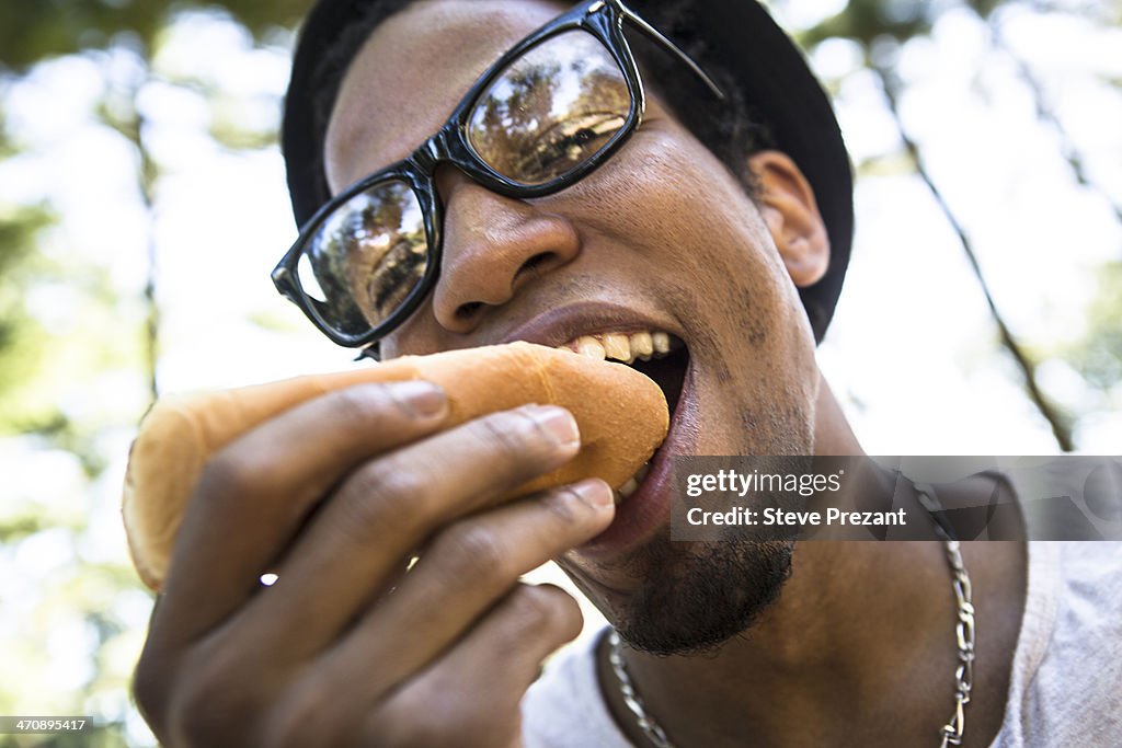 Young man eating bread roll