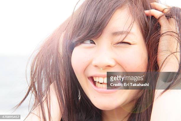 portrait of young woman, hands in hair, sticking tongue out - winking stock pictures, royalty-free photos & images