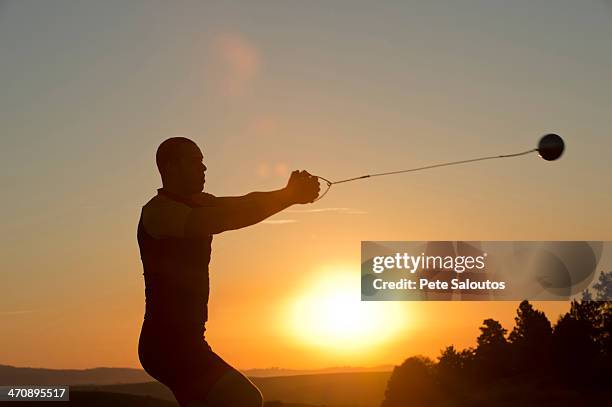 young man preparing to throw the hammer at sunset - ring toss bildbanksfoton och bilder