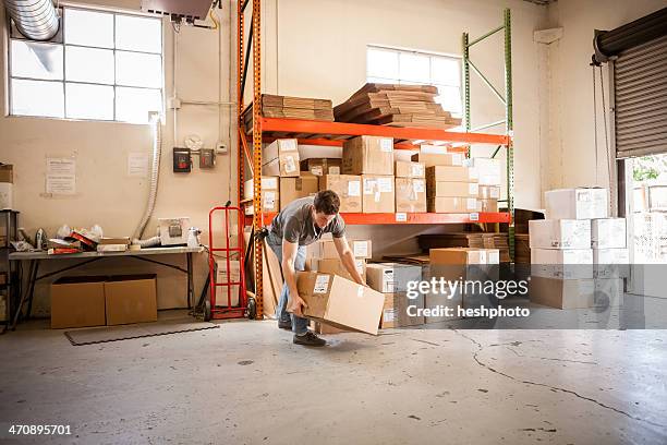 worker lifting cardboard box - box lifting technique stock-fotos und bilder