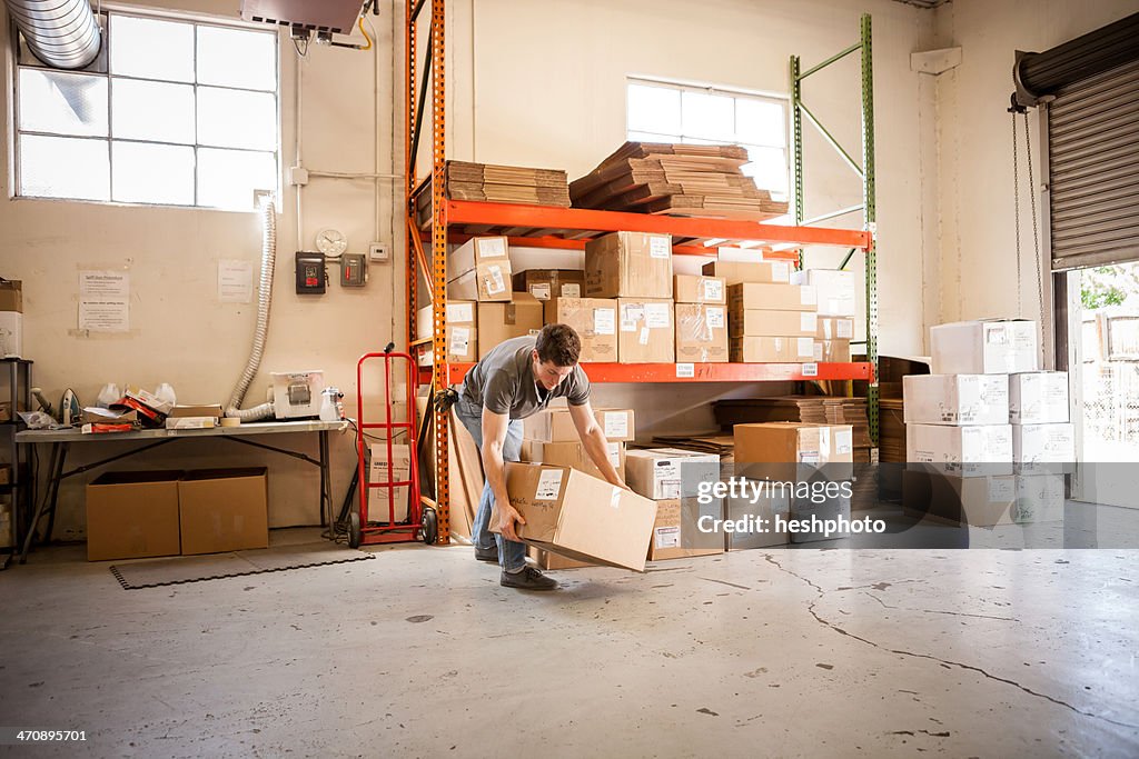 Worker lifting cardboard box