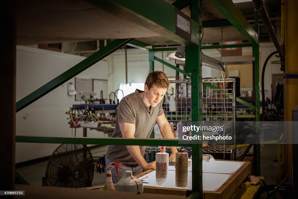 Worker in warehouse, looking at paperwork