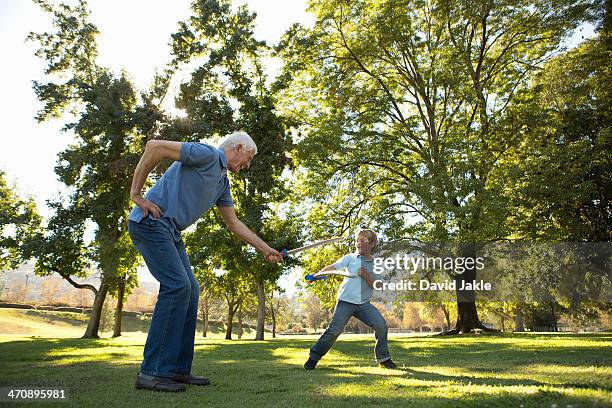 grandfather and grandson playfighting with toy swords - toy sword stock pictures, royalty-free photos & images