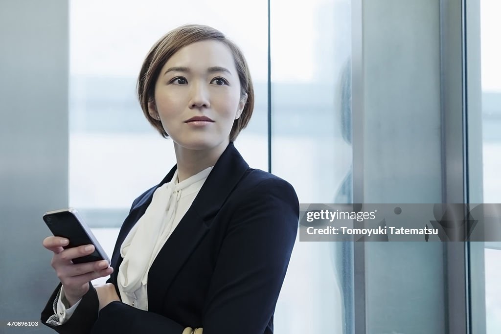 Portrait of young woman holding cell phone