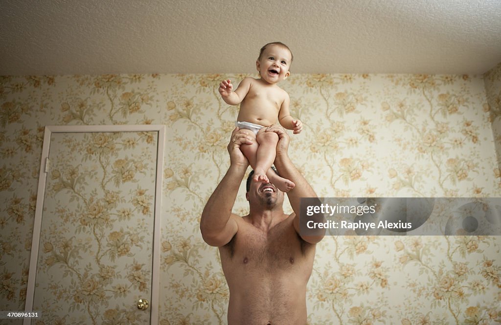 Grandfather holding baby granddaughter, low angle