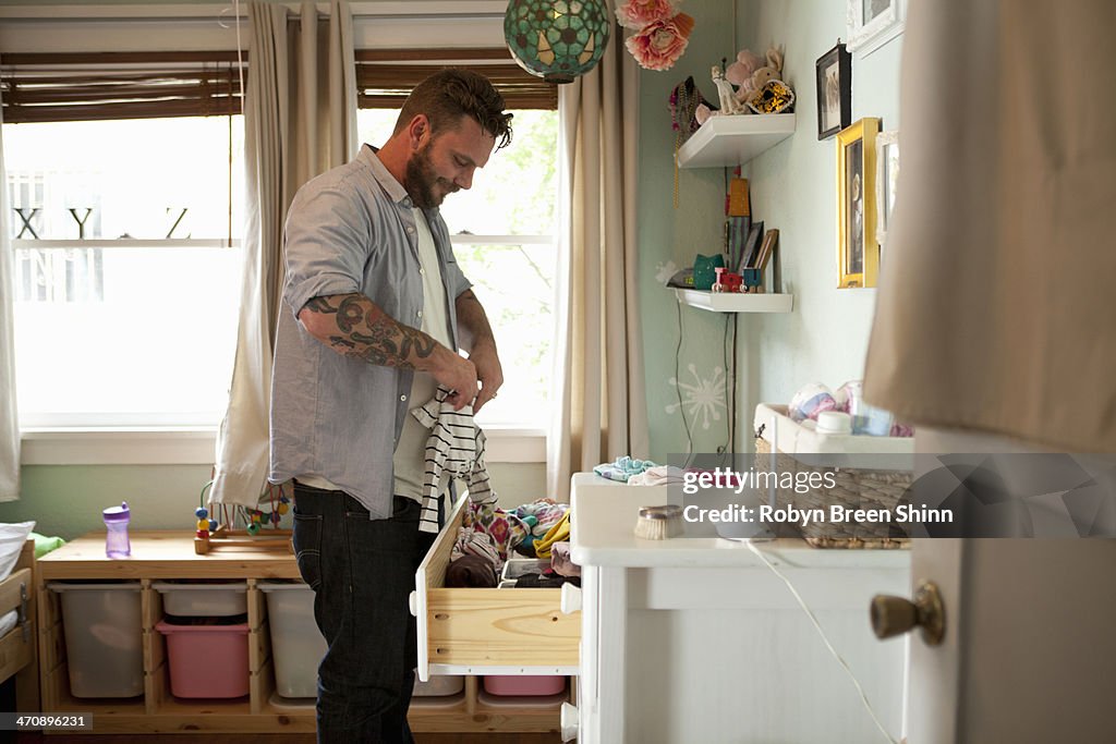 Father putting away child's laundry