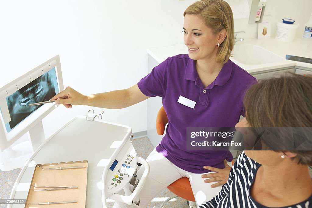 Dentist showing patient xray of dental implants