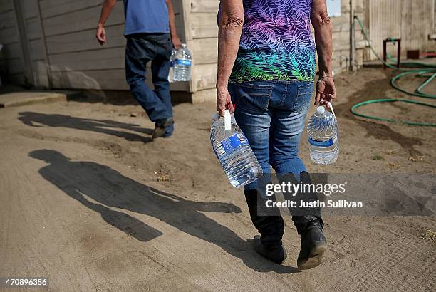 Donna Johnson delivers drinking water to a resident who has no running water on April 23, 2015 in Porterville, California. Over 300 homes in the...