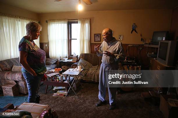 Porterville resident Manuel Dominguez , who has no running water, talks with Donna Johnson in his living room on April 23, 2015 in Porterville,...