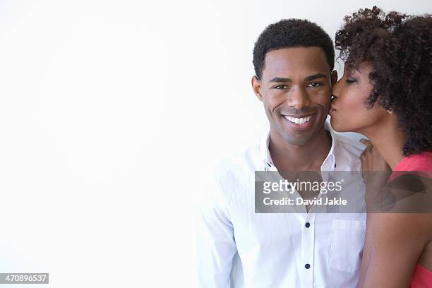 portrait of young woman kissing man on cheek - black women kissing white men - fotografias e filmes do acervo