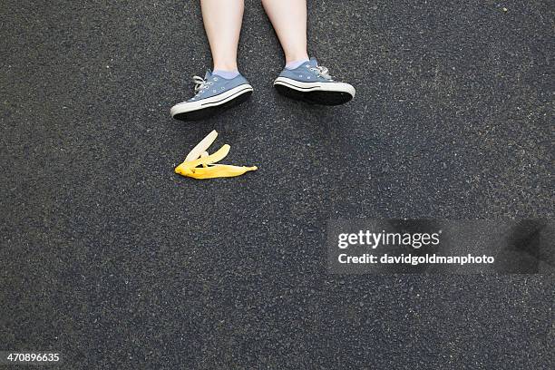 pair of legs and banana skin on tarmac - bio banane stock-fotos und bilder