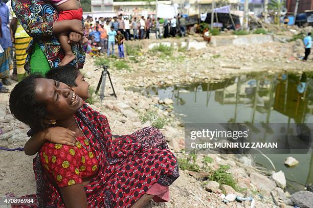 Bangladeshi relative of a victim of the Rana Plaza building collapse weeps as she marks the second anniversary of the disaster at the site where the...