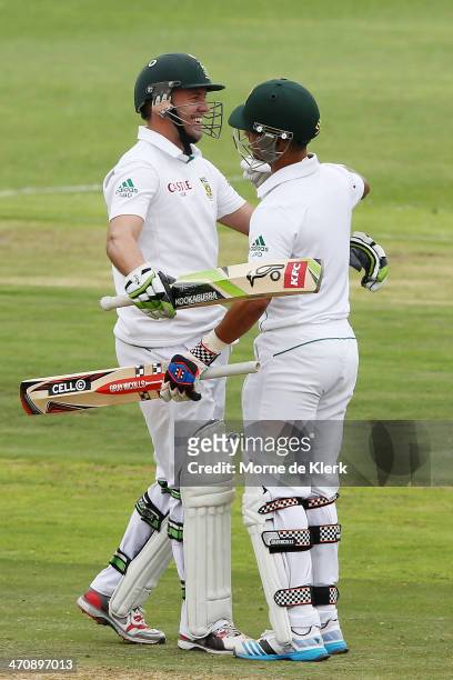 Duminy of South Africa congratulates his teammate AB de Villiers after De Villiers passed 100 runs during day two of the Second Test match between...