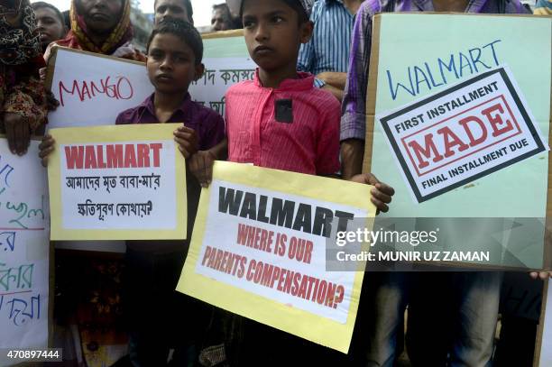 Bangladeshi children of victims of the Rana Plaza building collapse hold placards as they mark the second anniversary of the disaster at the site...