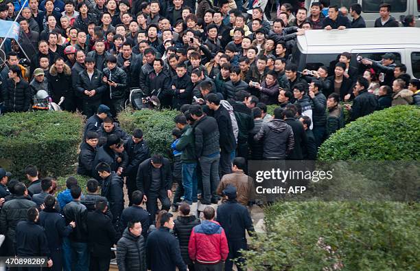 This picture taken on February 17, 2014 shows workers gathering on a square before the government headquaters in Wenling, east China's Zhejiang...