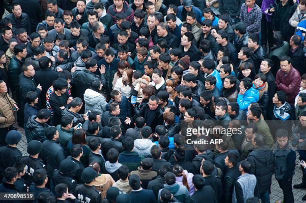 This picture taken on February 17, 2014 shows workers gathering on a square before the government headquaters in Wenling, east China's Zhejiang...