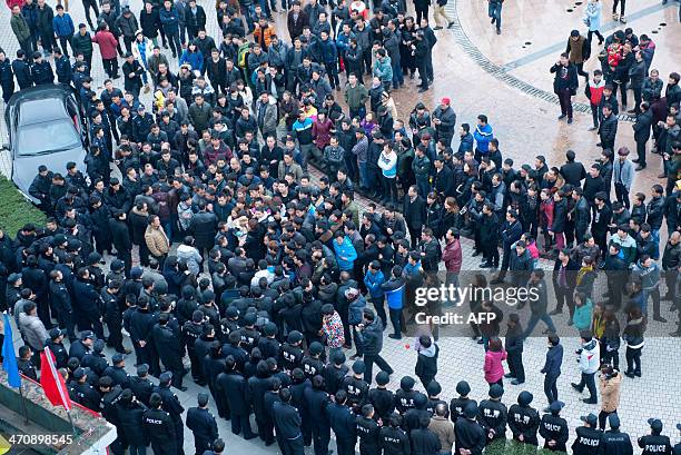 This picture taken on February 17, 2014 shows workers gathering on a square before the government headquaters in Wenling, east China's Zhejiang...