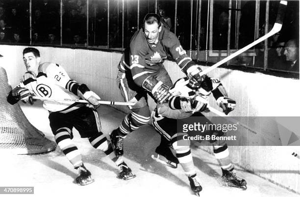 Eddie Shack of the Toronto Maple Leafs tries to get by Jean-Guy Gendron of the Boston Bruins as Gendron's teammate Irvin Spencer skates away from the...