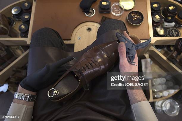 Jeremy Esterlich, shoeshine works in a shopping mall in Levallois-Perret, outside Paris, on February 13, 2014. AFP PHOTO / JOEL SAGET