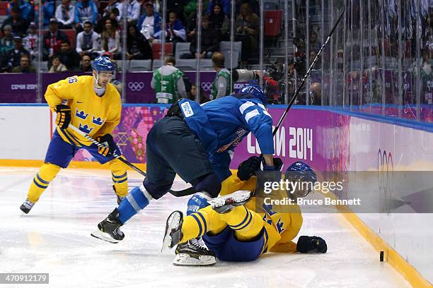 Ossi Vaananen of Finland knocks Jimmie Ericsson of Sweden to the ice during the Men's Ice Hockey Semifinal Playoff on Day 14 of the 2014 Sochi Winter...