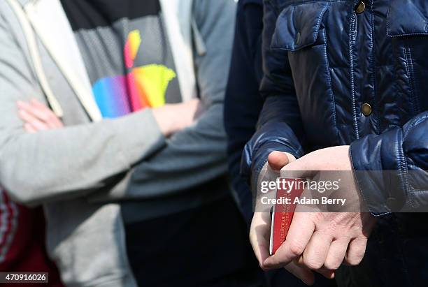 Russian Apple fan holds his passport as proof of his identification as he waits to purchase the new Apple Watch at The Corner luxury shop on April...