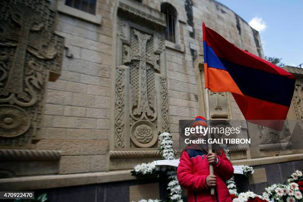 Young girl of the Armenian community holds the Armenian flag as she stands by the memorial monument on April 24, 2015 in Jerusalem's Old City, during...