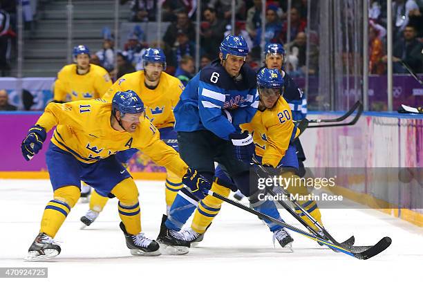 Daniel Alfredsson and Alexander Steen of Sweden challenge Sami Salo of Finland for the puck during the Men's Ice Hockey Semifinal Playoff on Day 14...