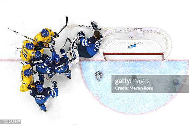 Kari Lehtonen of Finland loses his helmet against Patrik Berglund, Gabriel Landeskog and Alexander Steen of Sweden during the Men's Ice Hockey...